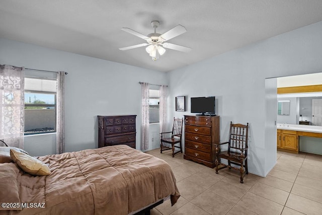 bedroom featuring light tile patterned floors, ceiling fan, and connected bathroom