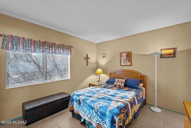 bedroom featuring baseboards and tile patterned floors