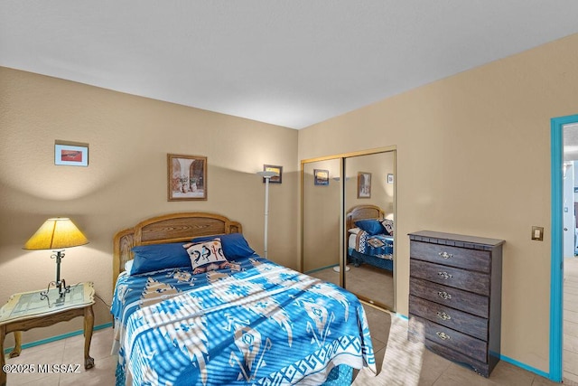 bedroom with light tile patterned floors, baseboards, and a closet