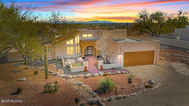 view of front of property with a garage, driveway, a mountain view, and stucco siding