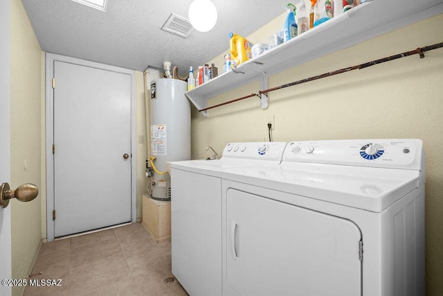 laundry area with gas water heater, visible vents, a textured ceiling, separate washer and dryer, and laundry area