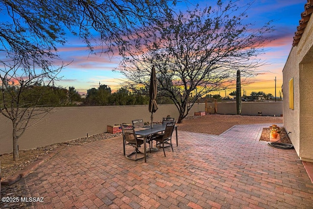 patio terrace at dusk with fence and outdoor dining space