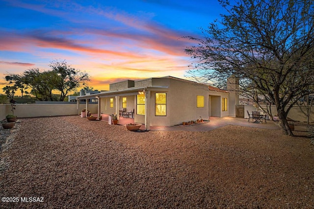 back of property with stucco siding, a fenced backyard, and a patio