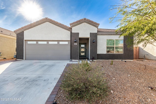 view of front of house featuring concrete driveway, a tile roof, an attached garage, and stucco siding