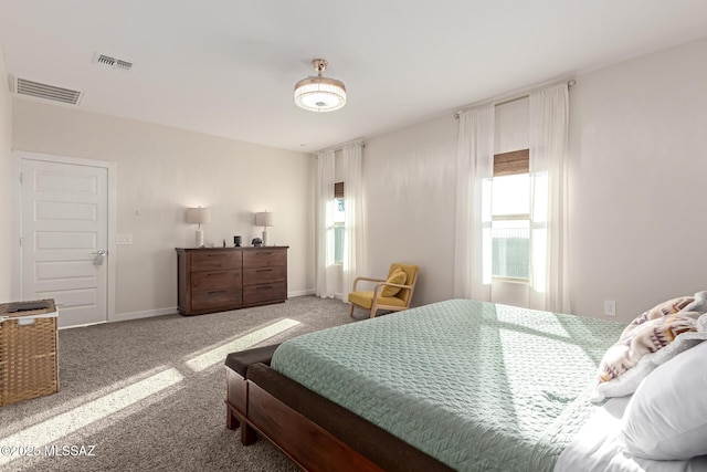 carpeted bedroom featuring visible vents, baseboards, and multiple windows