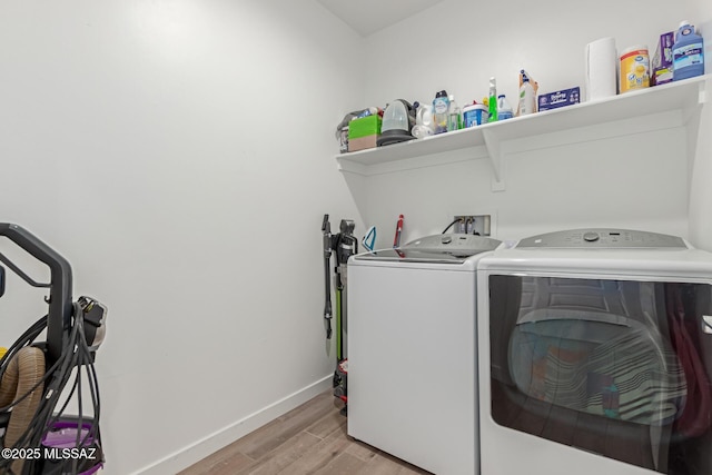 washroom with laundry area, independent washer and dryer, light wood-style flooring, and baseboards