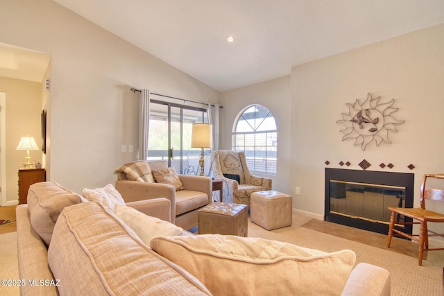 carpeted living area with a tile fireplace, baseboards, and lofted ceiling