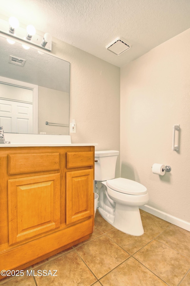 half bathroom with visible vents, a textured ceiling, toilet, and tile patterned flooring