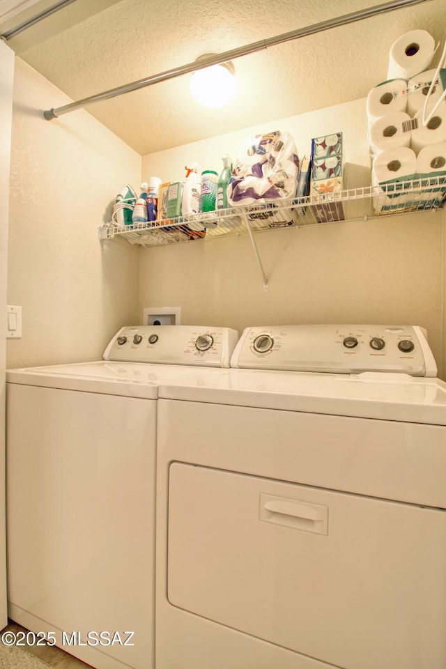 washroom featuring a textured ceiling, laundry area, and washer and clothes dryer