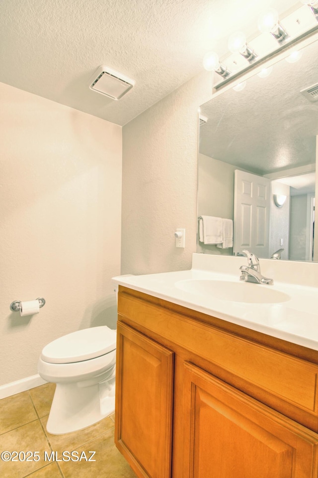 bathroom featuring a textured ceiling, toilet, tile patterned flooring, and vanity