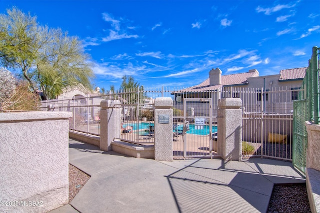 view of patio with a community pool and fence