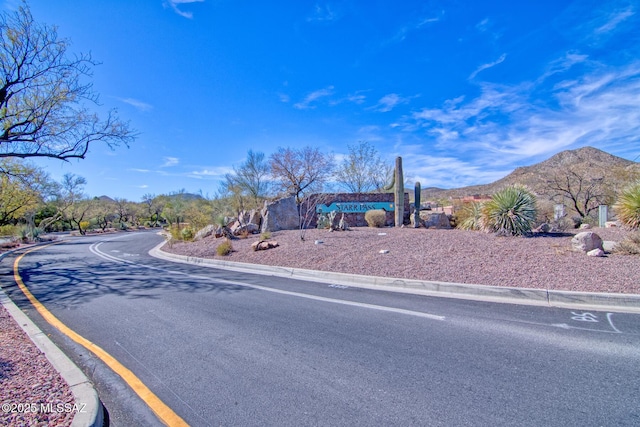 view of street with a mountain view and curbs