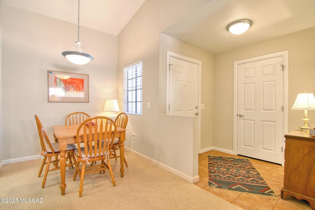 dining room with baseboards, lofted ceiling, and light tile patterned floors