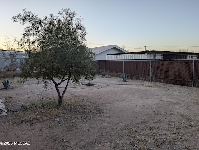 yard at dusk featuring fence