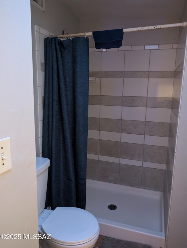 full bathroom with a shower stall and toilet