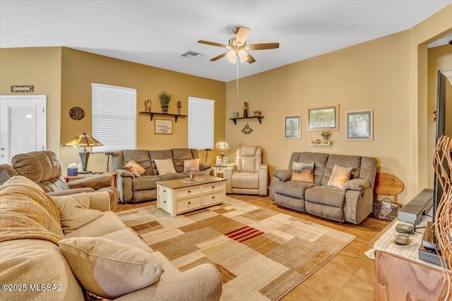 living area with ceiling fan, visible vents, and light tile patterned flooring