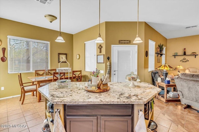 kitchen with a center island, visible vents, and decorative light fixtures