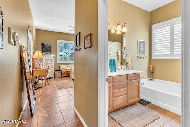 full bath with tile patterned flooring, a garden tub, vanity, and baseboards
