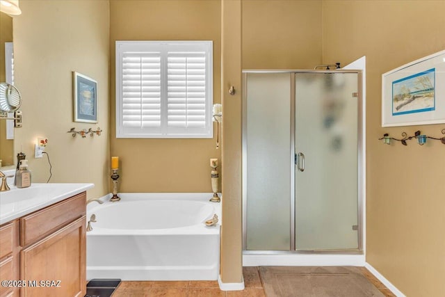 bathroom featuring a stall shower, a garden tub, vanity, and tile patterned floors