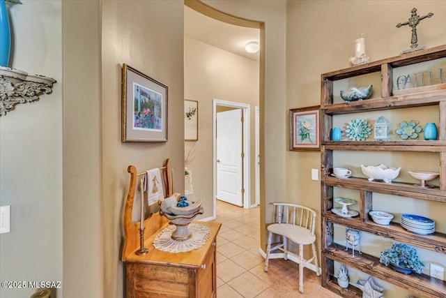 corridor with light tile patterned flooring and baseboards