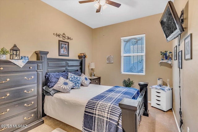 bedroom featuring light carpet, a ceiling fan, and baseboards