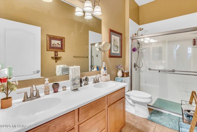 bathroom with double vanity, a stall shower, tile patterned flooring, and a sink