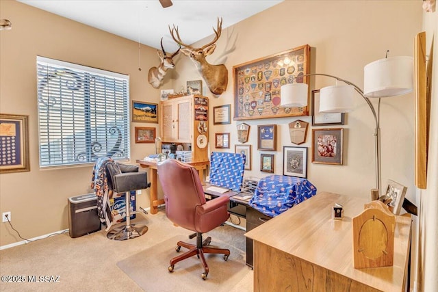 carpeted home office featuring a ceiling fan