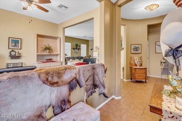 living room featuring light tile patterned floors, baseboards, visible vents, and ceiling fan