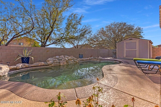view of swimming pool featuring a fenced backyard, a storage shed, an outdoor structure, a fenced in pool, and a patio area