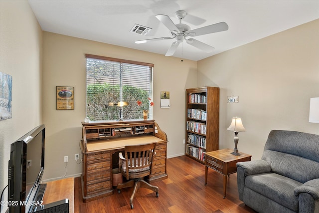 office space featuring a ceiling fan, baseboards, visible vents, and wood finished floors