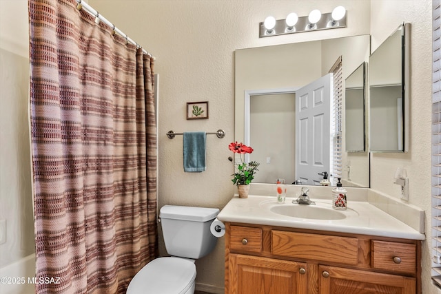 full bathroom with a textured wall, vanity, toilet, and shower / bath combo with shower curtain