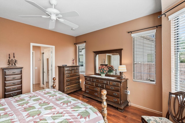 bedroom featuring ceiling fan, dark wood-style flooring, and baseboards