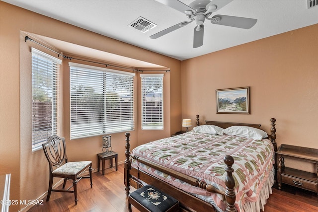 bedroom with wood finished floors, visible vents, and a ceiling fan