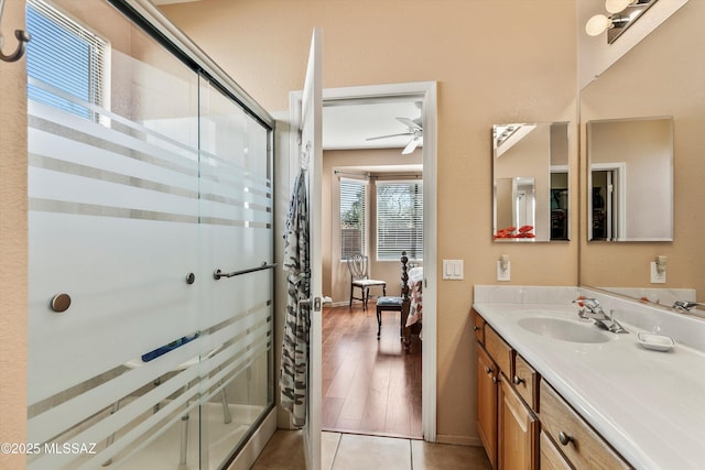 bathroom featuring a stall shower, ceiling fan, tile patterned flooring, and vanity