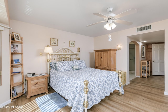 838 E Desert Glen Dr, Oro Valley, AZ 85755 - bedroom featuring arched walkways, wood finished floors, baseboards, and ceiling fan