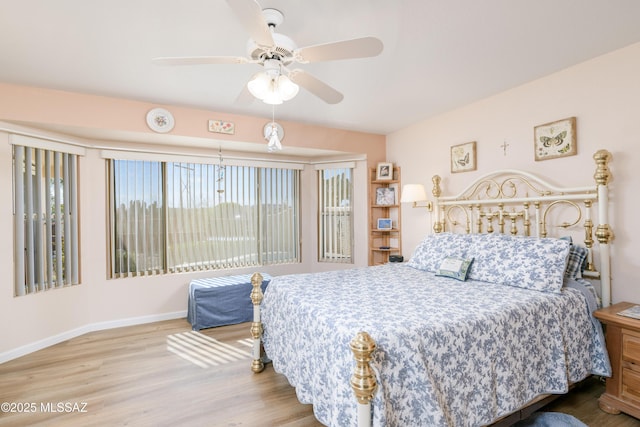 bedroom featuring a ceiling fan, baseboards, and wood finished floors