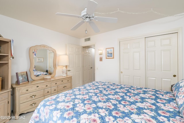 bedroom with ceiling fan, visible vents, and a closet