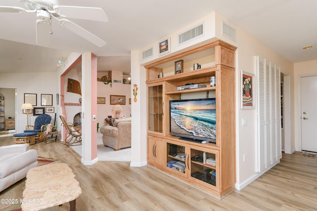 living area with light wood-style flooring and visible vents