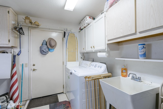 laundry area with washer and clothes dryer, a sink, and cabinet space