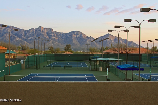 view of tennis court featuring fence and a mountain view