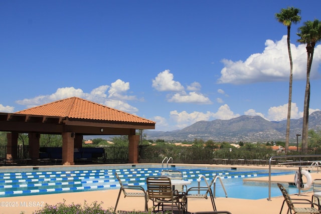 pool with a gazebo, a patio area, fence, and a mountain view