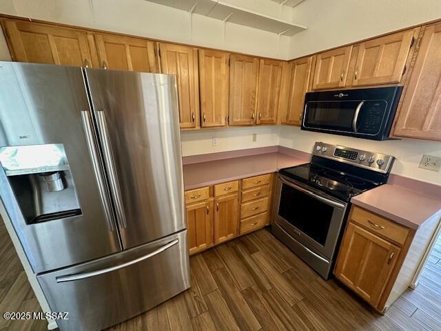 kitchen with brown cabinetry, stainless steel appliances, and light countertops