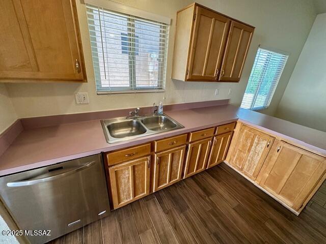 kitchen featuring a sink, dark wood finished floors, light countertops, and dishwasher