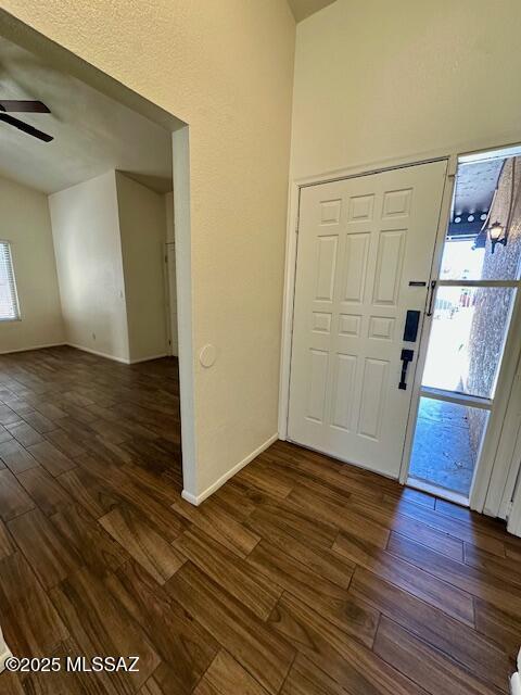 entryway featuring a ceiling fan, dark wood finished floors, and baseboards