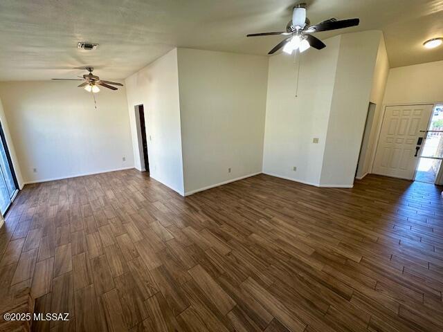 unfurnished room with ceiling fan, visible vents, and dark wood-type flooring