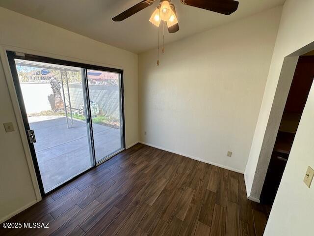 unfurnished room with dark wood-style floors, ceiling fan, and baseboards