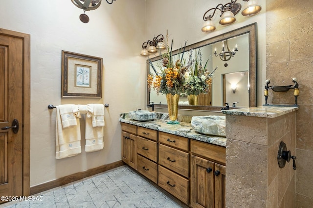 full bath featuring double vanity and baseboards