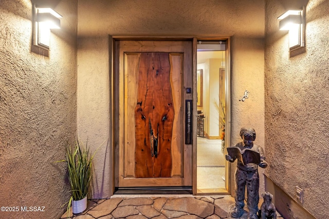 view of exterior entry with stucco siding