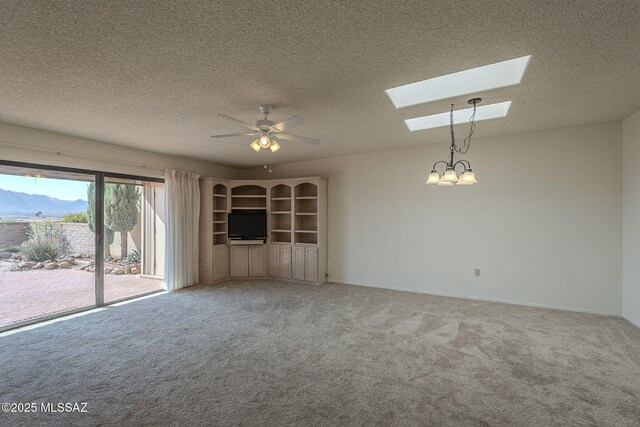 unfurnished office featuring light carpet, ceiling fan, a textured ceiling, and a mountain view