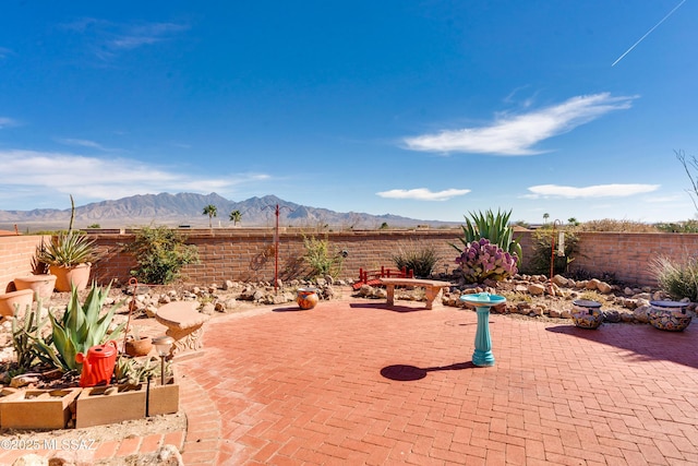 view of patio with a fenced backyard and a mountain view